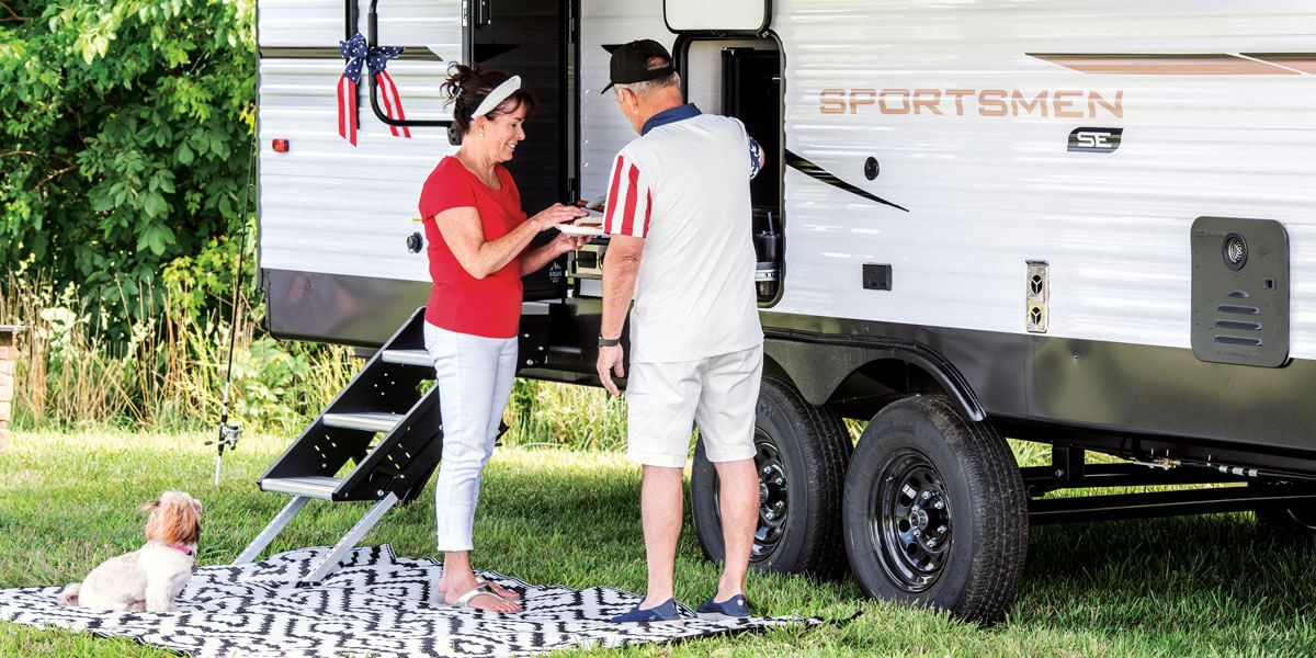 2025 KZ RV Sportsmen SE 292RBKSE Travel Trailer with Couple Preparing Food at Outside Kitchen